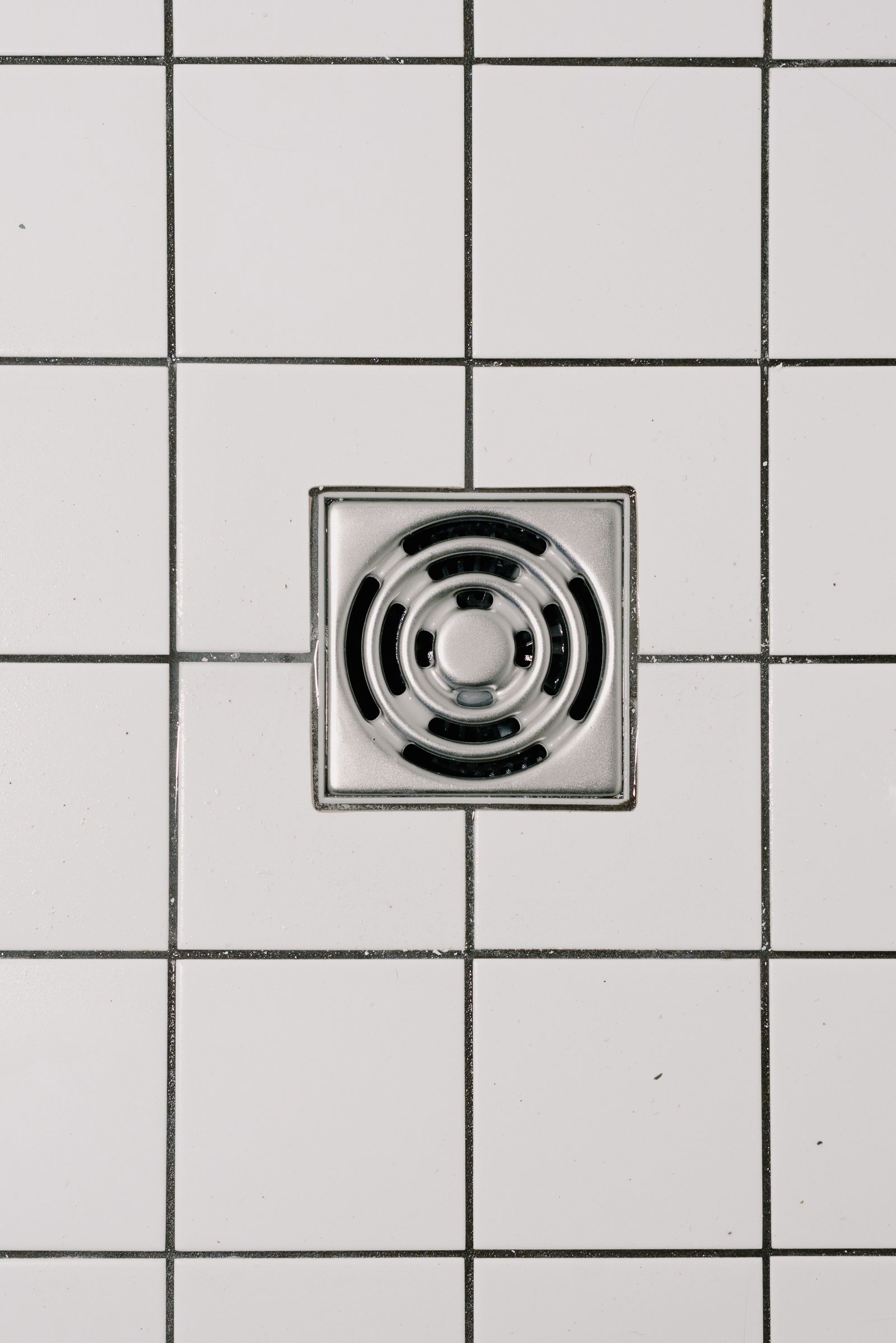 Modern shower drain set in white tile